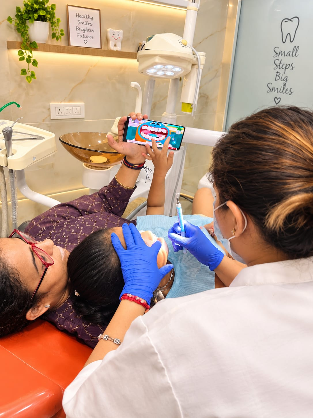 Young patient receiving attentive dental care with a parent nearby